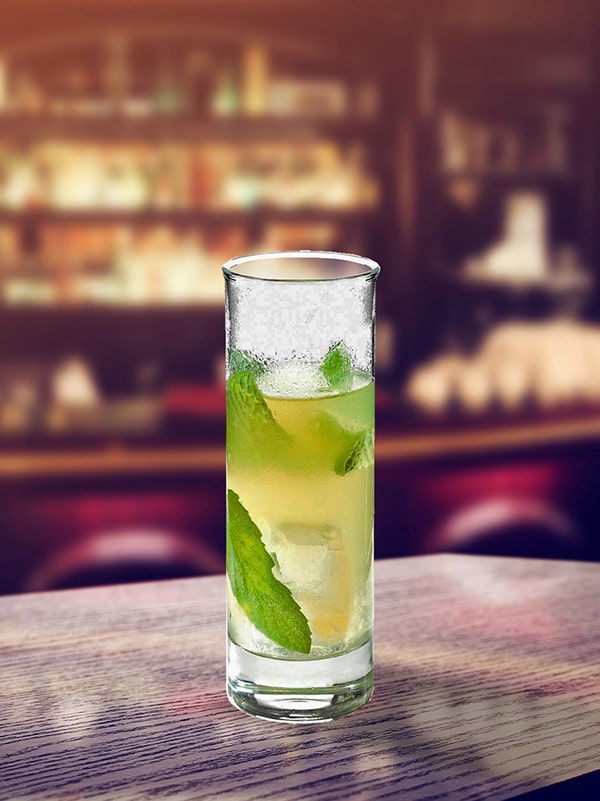 cocktail green label ans un verre long drink avec du citron dans un bar