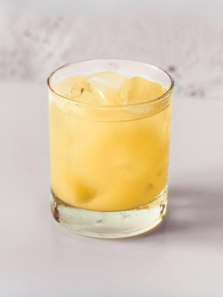 Recette de Cocktail exotique à base de liqueur de litchi et de nectar d'abricot servi dans un verre avec des glaçons.