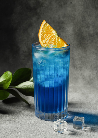 cocktail blue lagoon avec des quartiers d'orange et des glaçons