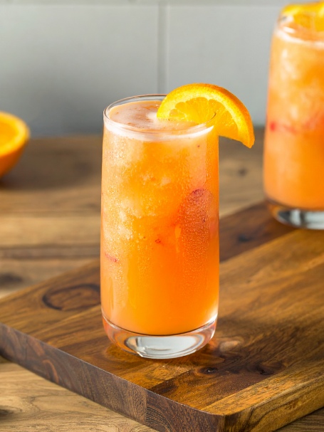 Cocktail 5th Avenue de couleur orange servi dans un verre long drink