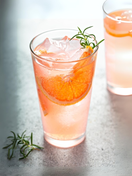 Cocktail Arktik avec vodka, jus de pomme, tranches de pamplemousse, menthe fraîche et miel