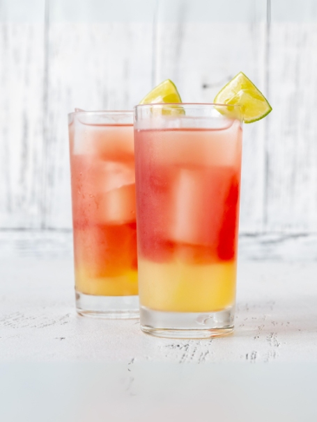 Cocktail Coucher de Soleil avec jus d'ananas, jus de framboise, nectar de mangue et sirop de canne