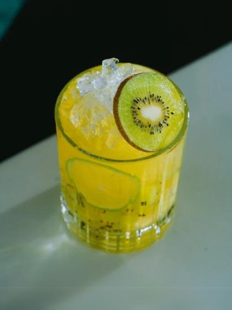 Cocktail Aguacanina avec cachaça Aguacana, sirop de vanille, sirop de canne, quartiers de citron vert et kiwi