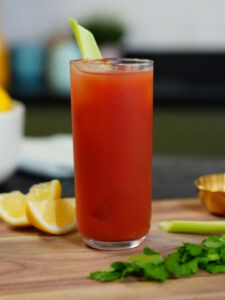 Cocktail Bloody Mary, recette salée à base de vodka et jus de tomate, servie dans un verre long drink et décoré d'une branche de céleri.