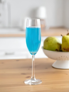 Cocktail Blue Up avec nectar de poire, curaçao bleu et champagne servi dans une flûte avec des glaçons et des feuilles de menthe fraiche