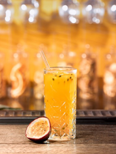 cocktail cario caraïbos fruit de la passion dans un verre long drink avec de la mangue et du citron vert