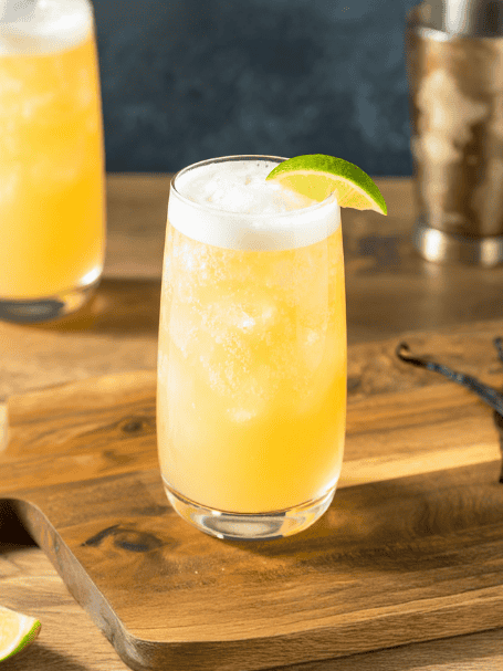Cocktail avec du rhum, jus de citron et ginger beer servi dans un verre long drink décoré avec une tranche de citron vert