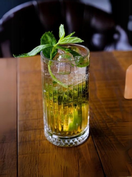 Cocktail Fortaleza avec cachaça Aguacana, soda au gingembre, citron vert frais, rondelles de gingembre, et des feuilles de menthe