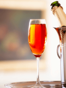 Verre de Kir Royal avec champagne et crème de cassis, servi dans une flûte à champagne.