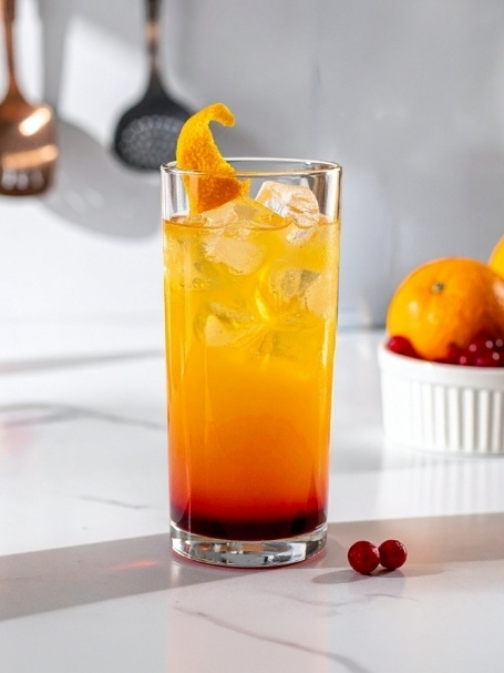 Cocktail Label Sunrise dans un verre long drink, à base de Blended Scotch Whisky Label 5, de jus d'orange et de sirop de grenadine Sirop Sport.