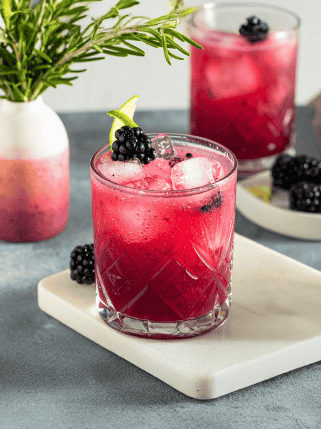 Cocktail Mora avec du Porto et de la crème de mûre, servi dans un verre avec des glaçons.