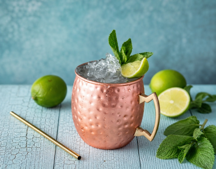 Cocktail Moscow Mule à la vodka et ginger beer, servi dans un mug en cuivre avec des glaçons, du citron vert et des feuilles de menthe