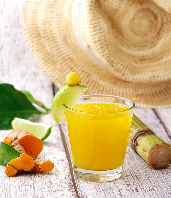 cocktail plein soleil verre orange avec citron vert et bambou