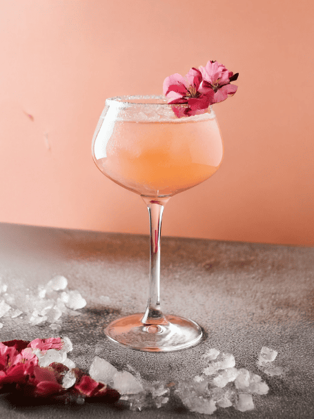 Cocktail avec de la crème de pamplemousse et du muscat de Rivesaltes rosé servi dans un verre à vin.