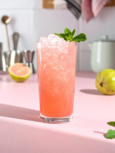 Cocktail Samba Sun, à base de Caraibos mojito et goyave avec des feuilles de menthe, dans un verre long drink.