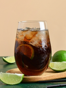 Cocktail Spiced Cola, à base de Rhum Black Spiced Rivière du Mât, de Cola et de citron vert, dans un verre tumbler avec des glaçons.