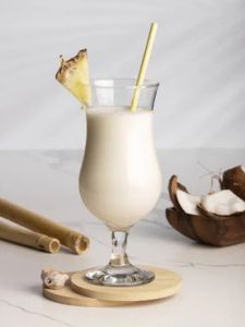 Cocktail Spicy colada ananas coco et rhum servi dans un verre décoré avec une tranche d'ananas