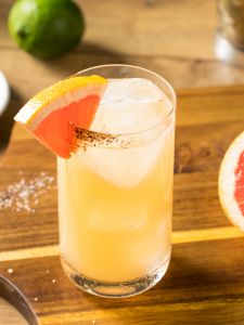 Cocktail Spicy Paloma avec jus de pamplemousse et piment servi dans un verere décoré avec une tranche de pamplemousse
