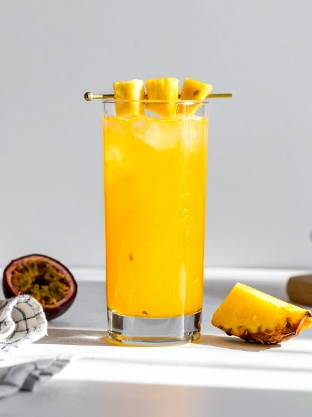 Cocktail Spicy Planteur dans un verre long drink, à base de Rhum blanc agricole Dillon, de sirop d'épices, de nectar de maracujà Caraïbos, de jus de citron vert pressé et de jus d'ananas Caraïbos.