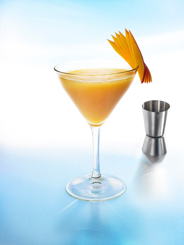cocktail spicy mango avec mangue bord du verre et fond bleu