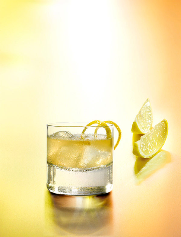 cocktail whisky sour avec un verre old fashioned avec des quartiers de citrons jaune