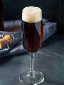 cocktail black velvet à base de champagne et de bière stout servi dans une flûte à champagne.