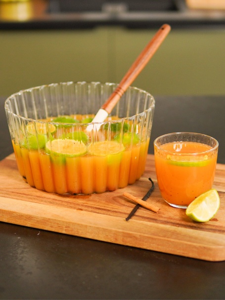 Punch à base de rhum, de nectars de goyave, mangue et fruits de la passion, présenté dans un saladier avec du citron vert.