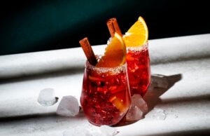 cocktails orangés au vermouth servi avec des glaçons, de l'orange et de la canelle