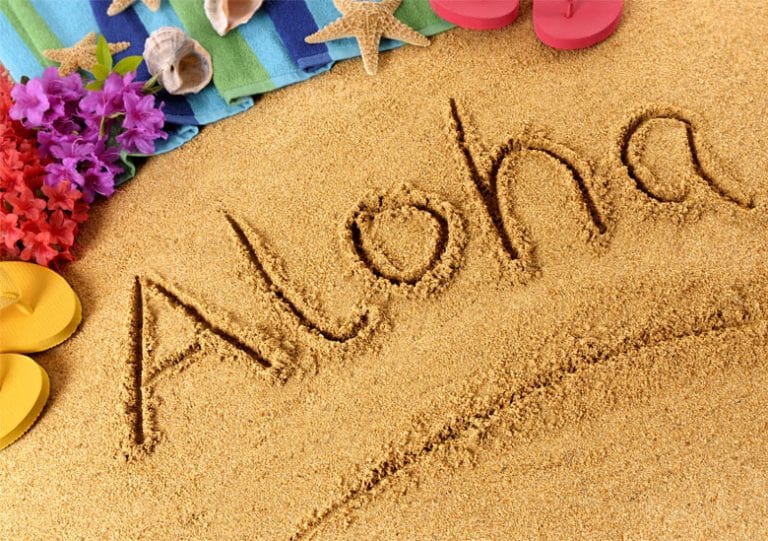 Theme soiree a hawai avec Aloha écrit dans le sable