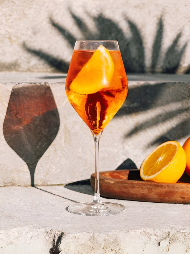 Cocktail Spritz dans un verre à Spritz, agrémenté d'une tranche d'orange.