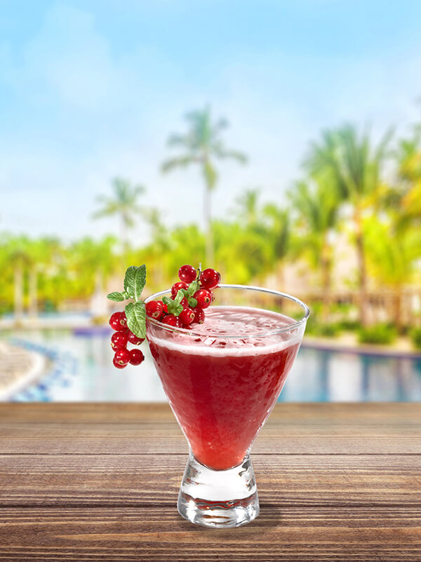 cocktail queen delight dans un verre avec de la glace pilée et une grappe de groseille