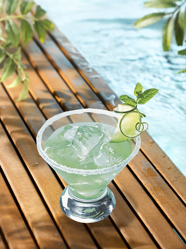 Cocktail gin daisy avec verre, zeste de pomme, menthe fraiche et tranche de citron vert