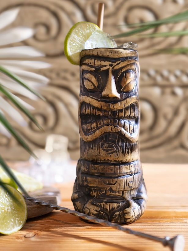 cocktail tiki mai tai dans un verre traditionnel tiki avec des glaçons e du citron vert