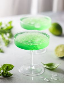 Cocktail Green Basil gimlet avec du gin et du basilic servi dans un verre en forme de coupe