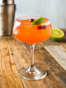 Cocktail Mer de Glace dans un verre à cocktail, à base de Vodka Poliakov, jus de cranberry, nectar de maracujà, sirop de canne Canadou et une branche de citronnelle.