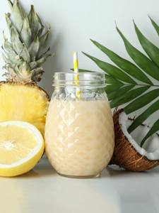Cocktail sans alcool Colada à base de jus d'ananas, de crème de coco et de sirop de canne, dans une jar.