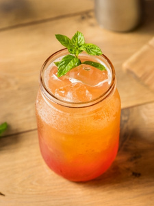 Cocktail Punch sans alcool servi dans un verre avec des feuilles de menthe en décoration.