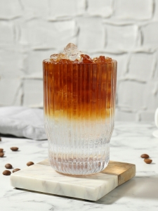 Cocktail Espresso Tonic servi dans un verre long drink rempli de glaçons.