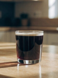 cocktail embuscade à base de bière, de calvados, de vin blanc, de sirop de citron et de sirop de cassis, servi dans un verre tumbler.