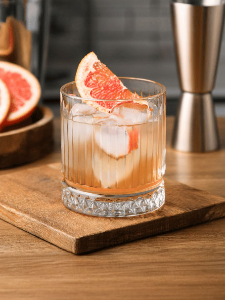 Cocktail Cap Horn, une recette à base de rhum servi dans un verre décoré avec un quartier de pamplemousse