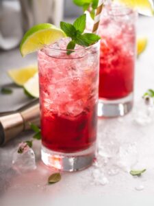 Cocktail Cape Codder, à base de vodka, jus de cranberry et jus de citron vert, servi dans un verre highball décoré d'un quartier de citron vert.