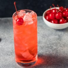 Cocktail sans alcool Shirley Temple, dans un verre tumbler garni d'une cerise confite.