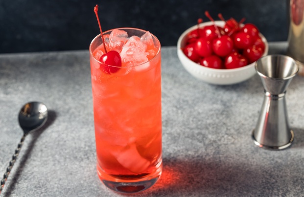 Cocktail sans alcool Shirley Temple, dans un verre tumbler garni d'une cerise confite.