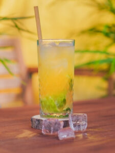 Cocktail Caipirinha au fruit de la passion, présenté dans un grand verre.