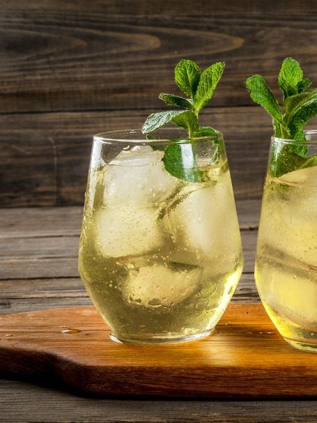 Cocktail Rebujito présenté dans un petit verre, décoré d'un brin de menthe.