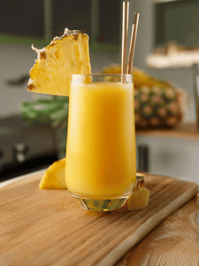 Cocktail Passion Tropicale sans alcool avec du fruit de la passion et de l'ananas, dans un verre décoré avec une tranche d'ananas.