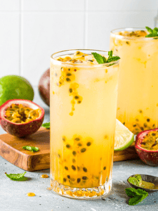 Cocktail sans alcool avec eau gazeuse et fruit de la passion servi dans un verre décoré avec des feuilles de menthe