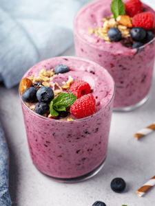 smoothie framboises myrtilles, décoré avec des fruits sur le dessus du verre
