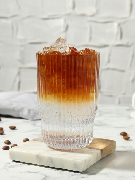 Cocktail Espresso Tonic servi dans un verre long drink rempli de glaçons.