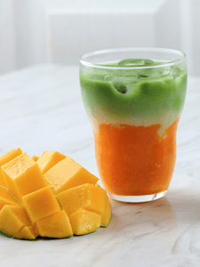 Cocktail mango matcha latte avec du thé matcha, de l apurée de mangue et du lait sucré